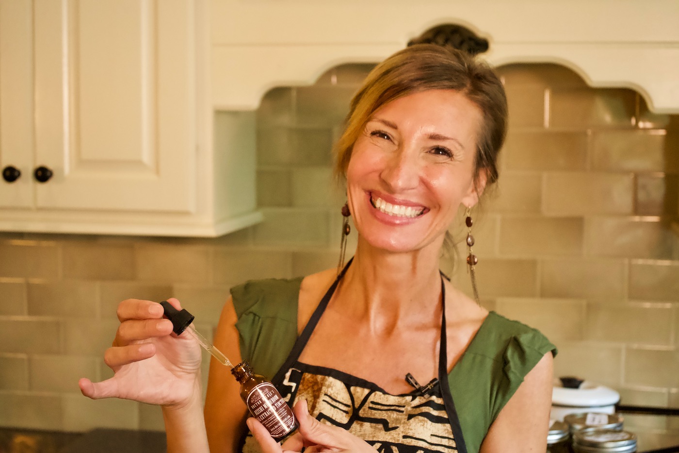 Nicole Apelian holding Reishi Tincture dropper and bottle Nicole taking tincture