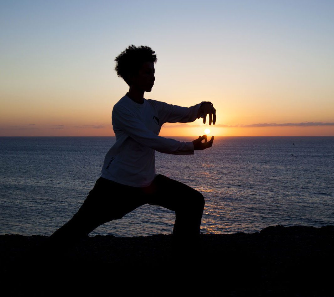 person-doing-tai-chi-on-beach-sunset Alleviating Knee Osteoarthritis Effectively With Simple Exercises