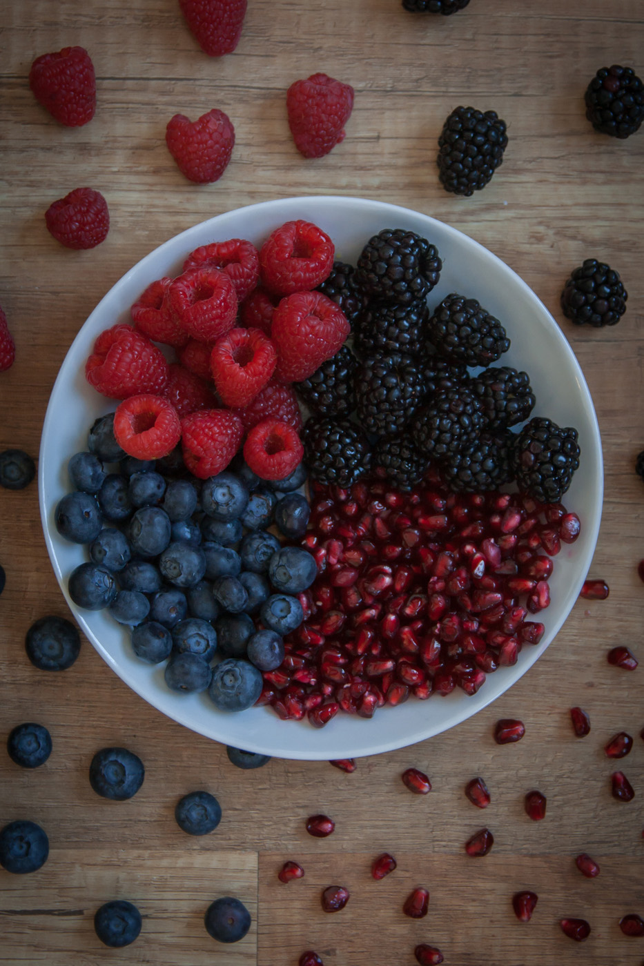 Flowered Citronella Plant in Garden bowl of raspberries, blackberries, blueberries, and pomegranate seeds