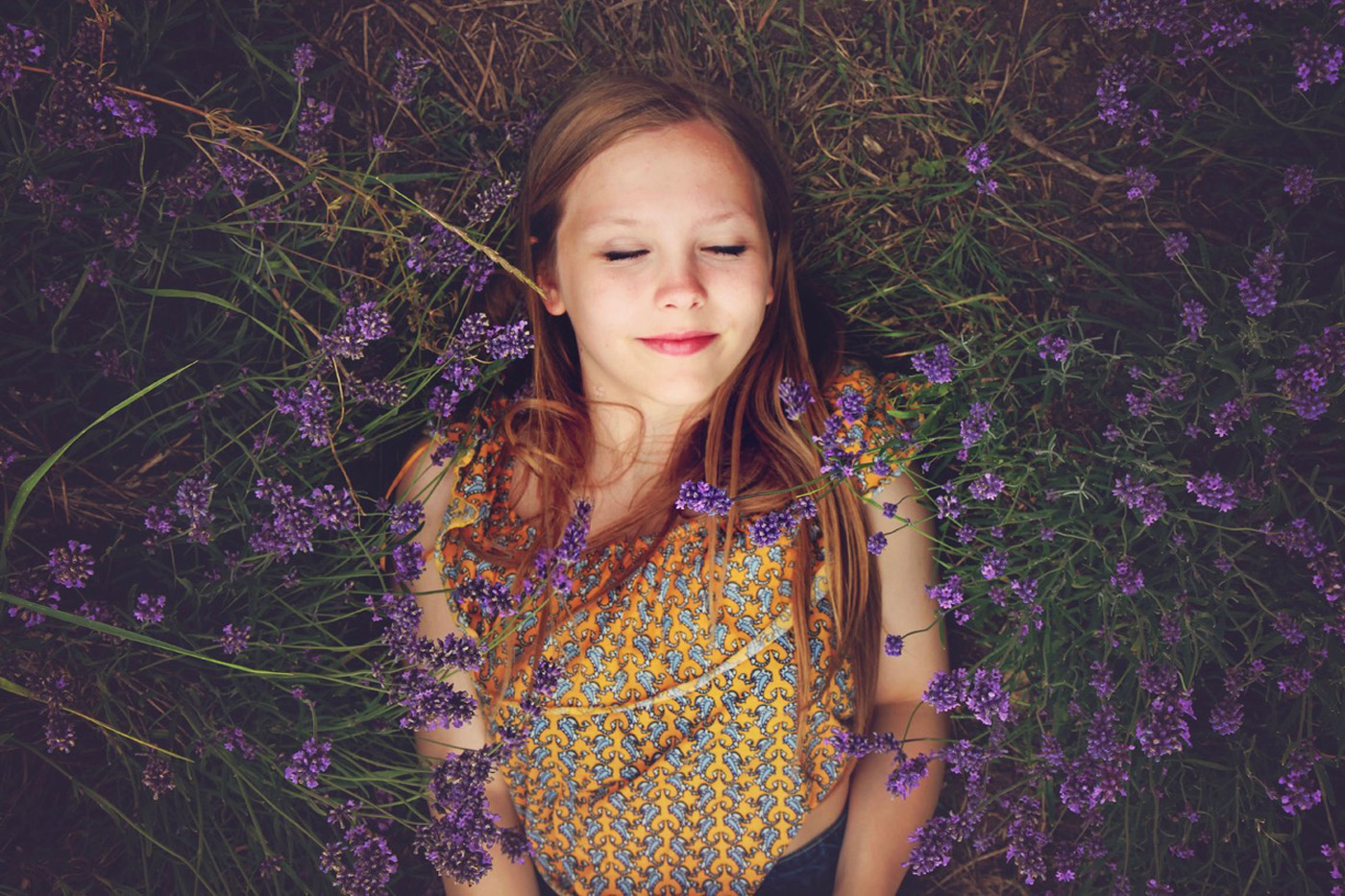 woman smiling with eyes closed taking a break in a field of purple flowers woman smiling with eyes closed taking a break in a field of purple flowers