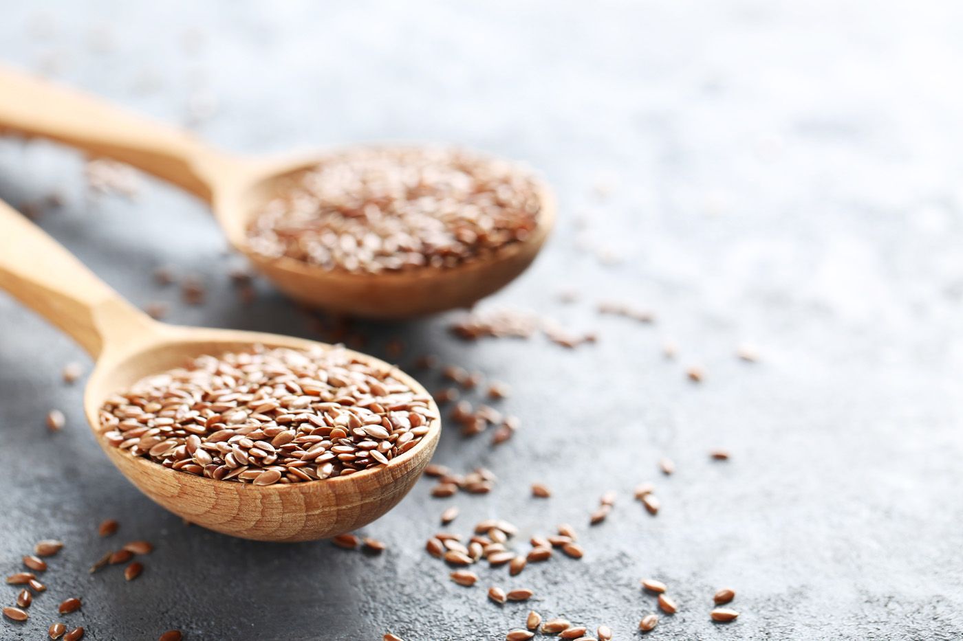 Brown flax seeds on grey wooden table Brown flax seeds on grey wooden table