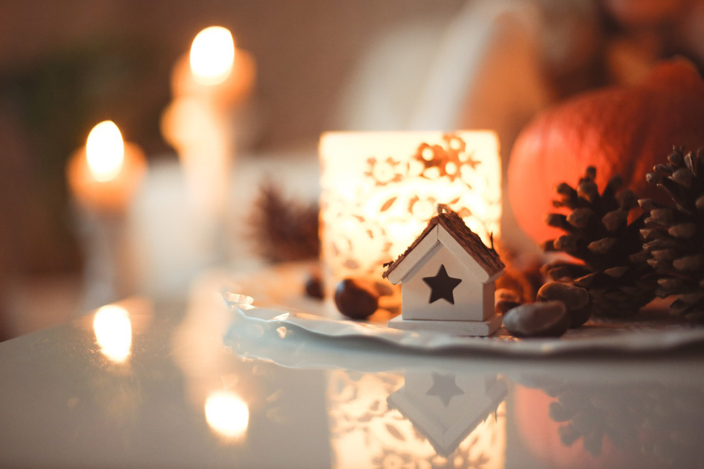 candlelight in autumn scene with pumpkin pine cones and house ornament candlelight in autumn scene with pumpkin pine cones and house ornament