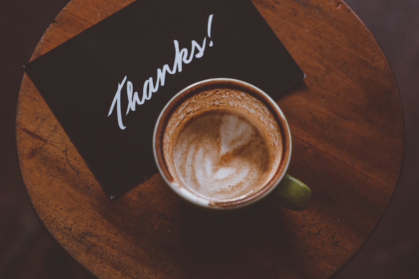 Nicole Apelian playing in tree cup of coffee with heart and thank you card