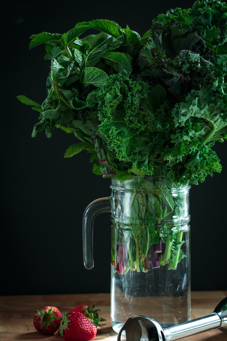 leafy greens kale in glass pitcher with strawberries leafy greens kale in glass pitcher with strawberries