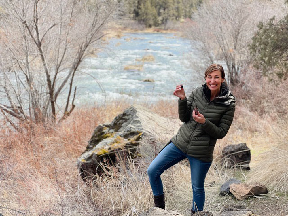 Nicole Apelian holding tincture by the river Nicole Apelian holding tincture by the river