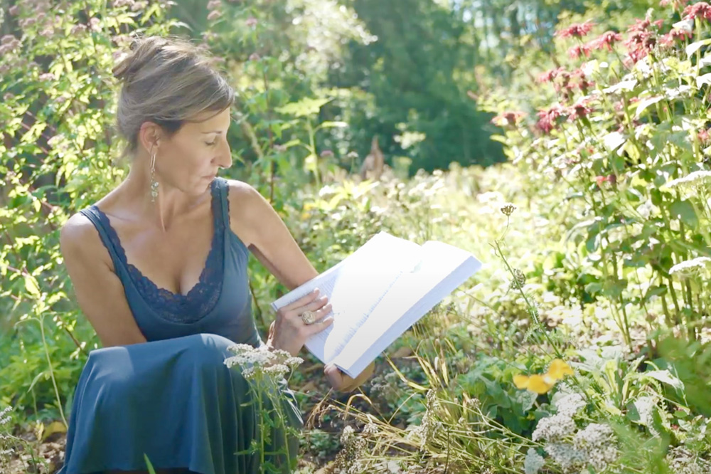 Nicole Apelian in garden with book bee balm Nicole Apelian in garden with book bee balm
