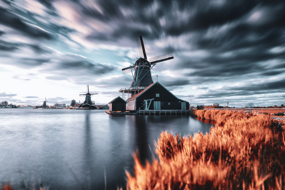 windmills on river with stormy sky windmills on river with stormy sky