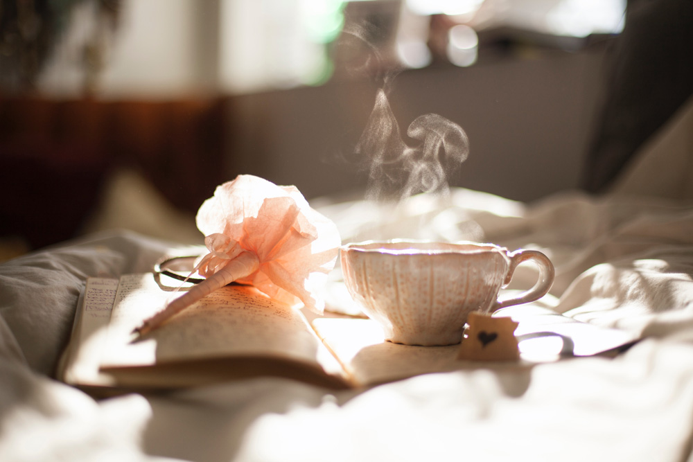 steaming cup of tea next to journal and pen steaming cup of tea next to journal and pen