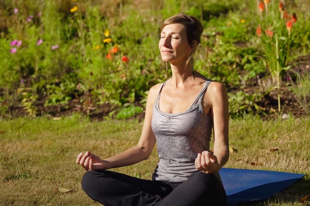 Nicole Apelian sitting practicing yoga outside