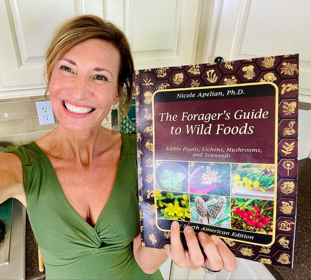 Nicole Apelian holding copy of The Forager's Guide to Wild Foods Nicole Apelian holding copy of The Forager's Guide to Wild Foods