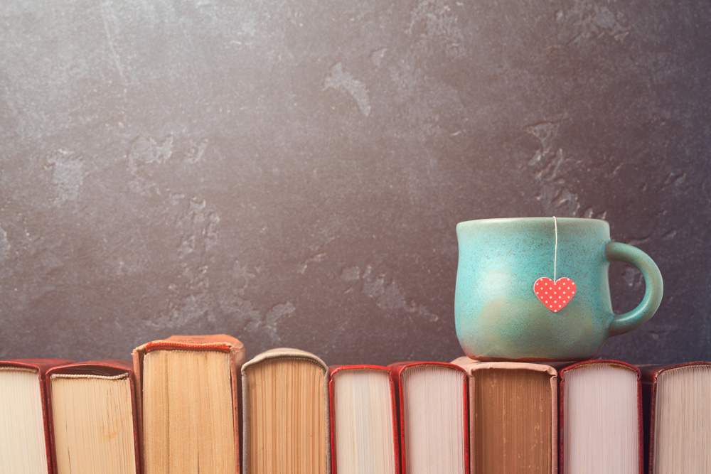 tea cup with heart on books over blackboard bac tea cup with heart on books over blackboard bac
