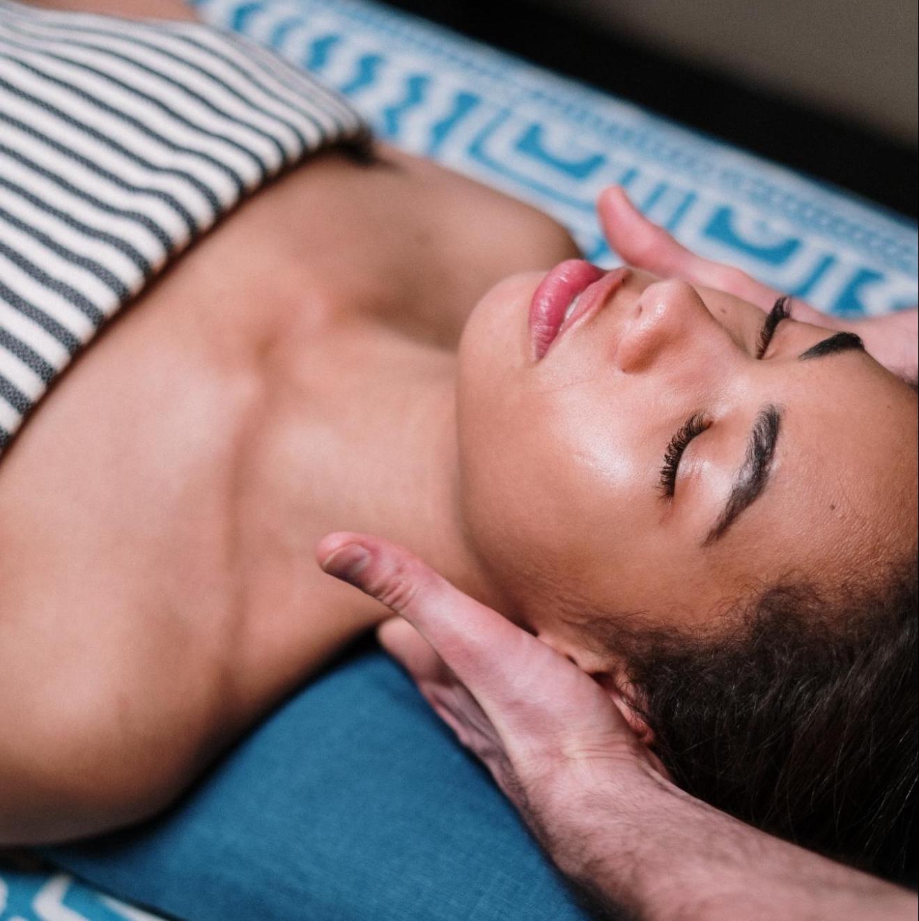 woman with eyes closed on table getting massage woman with eyes closed on table getting massage