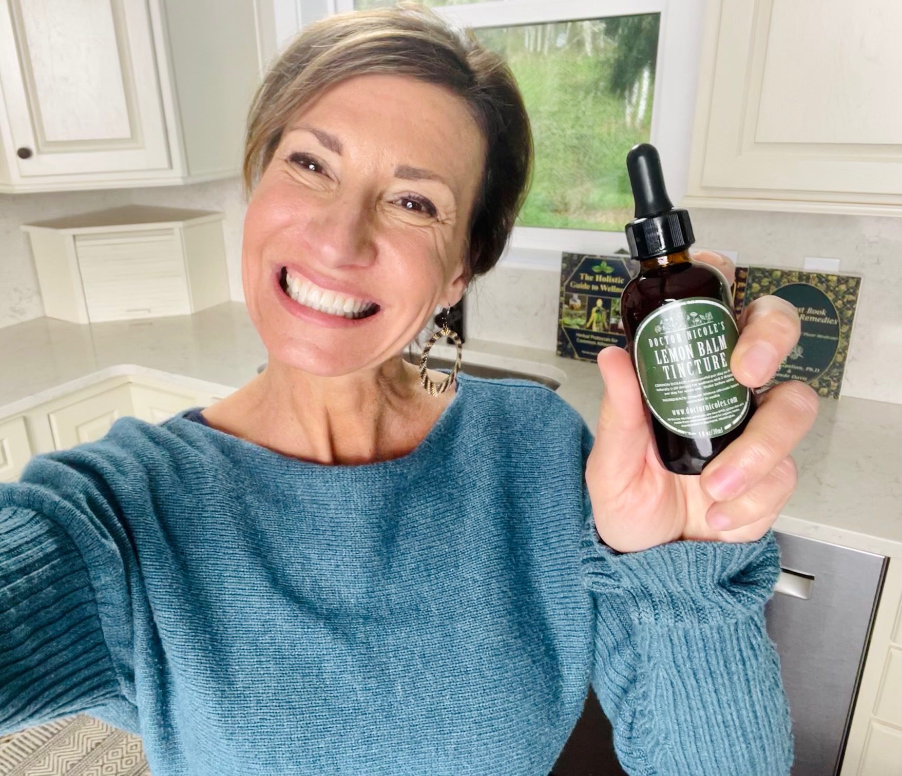 Nicole Apelian holding Nicoles Apothecary Lemon Balm Tincture Nicole Apelian holding Nicoles Apothecary Lemon Balm Tincture