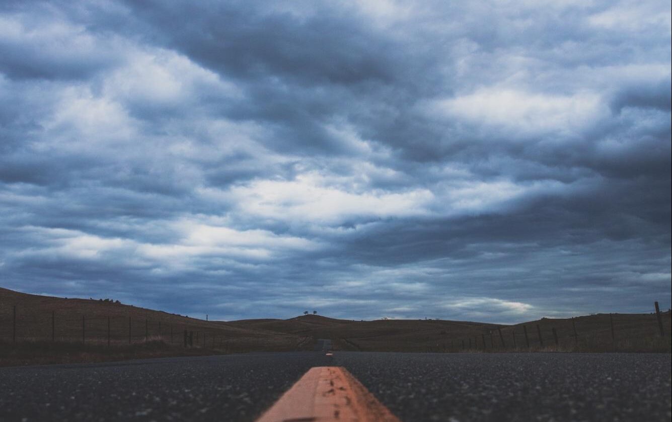 deserted road under cloudy sky