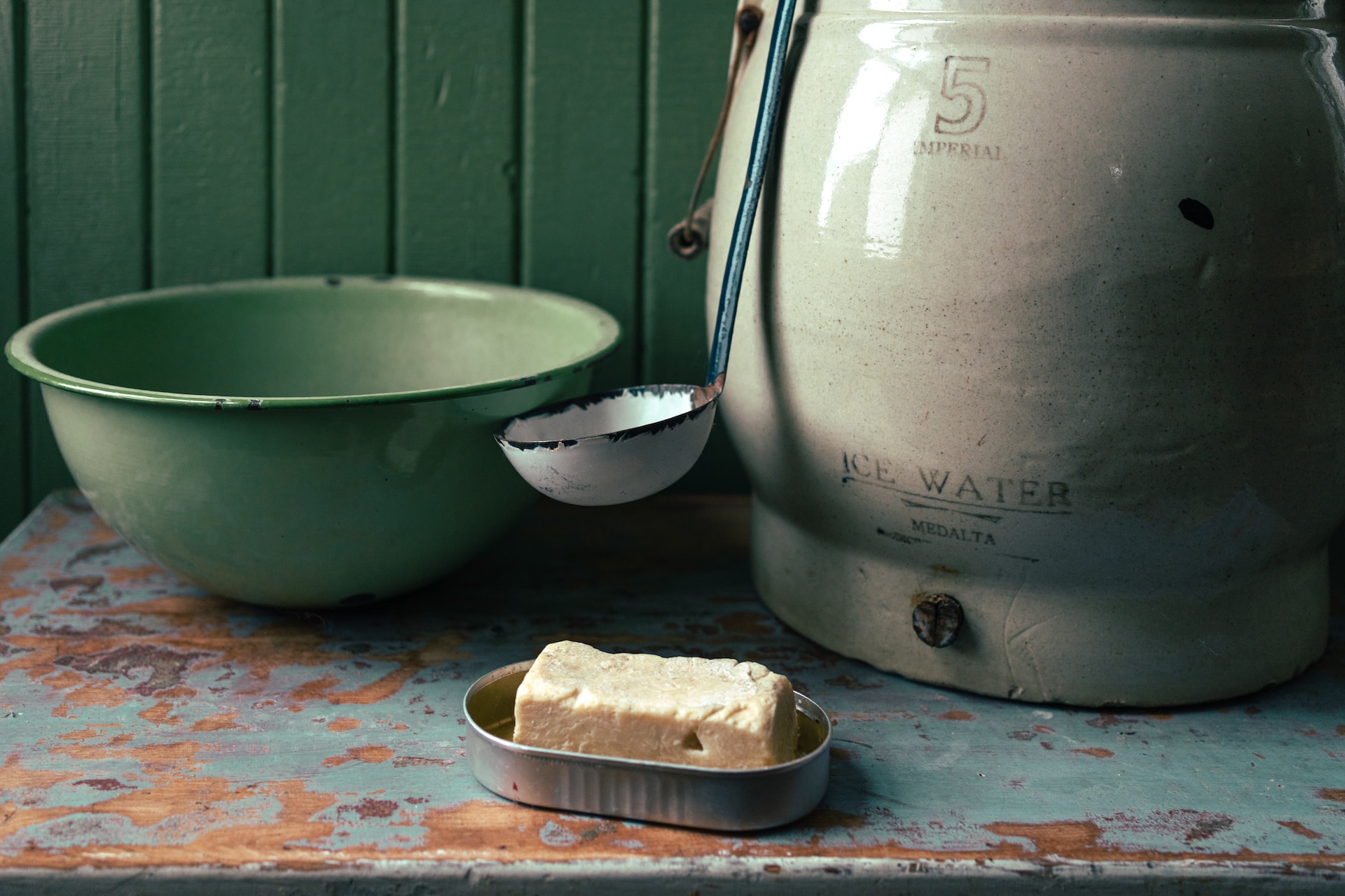 tin with bar of soap and water jug
