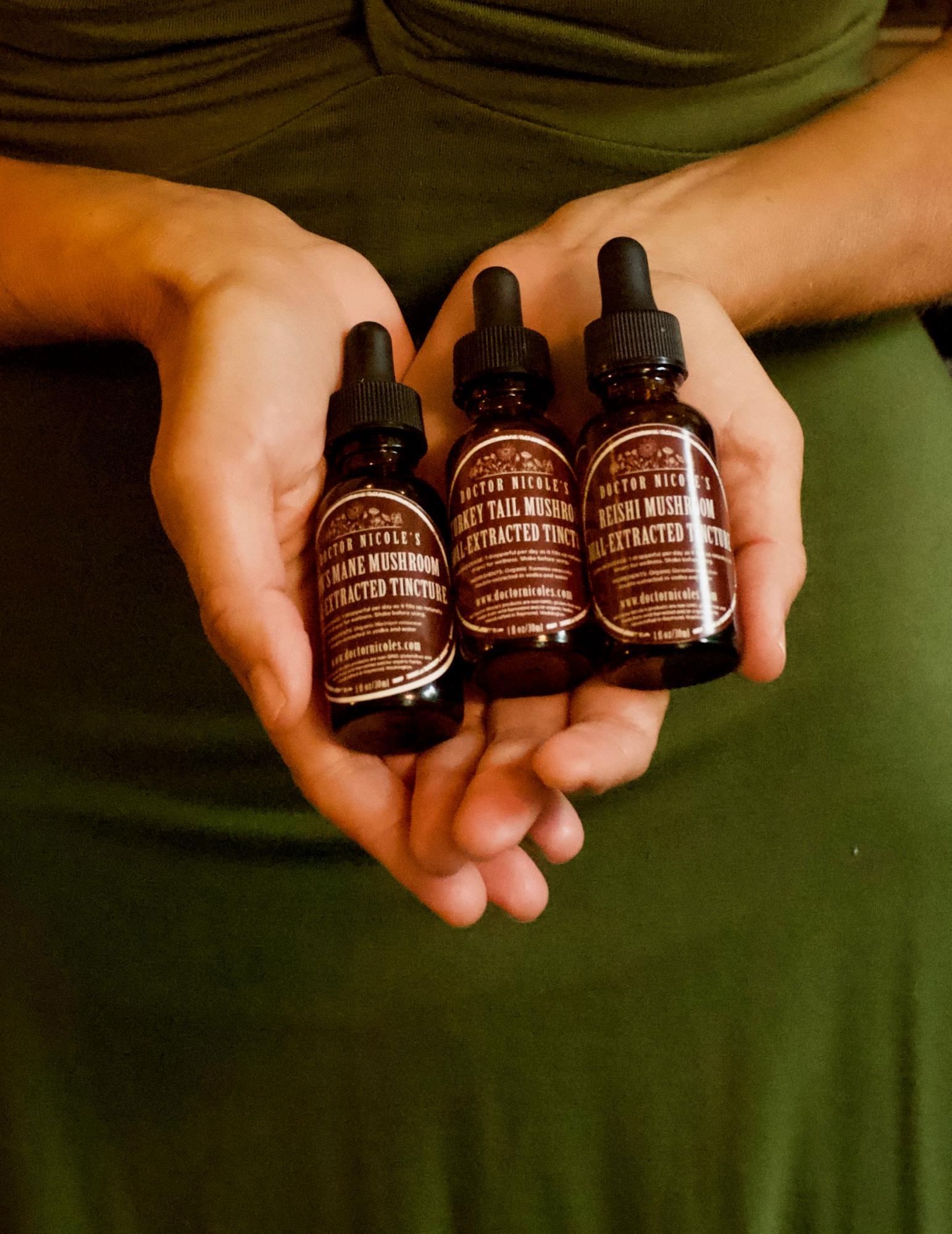Nicole Apelian holding her Mushroom Trio of tinctures