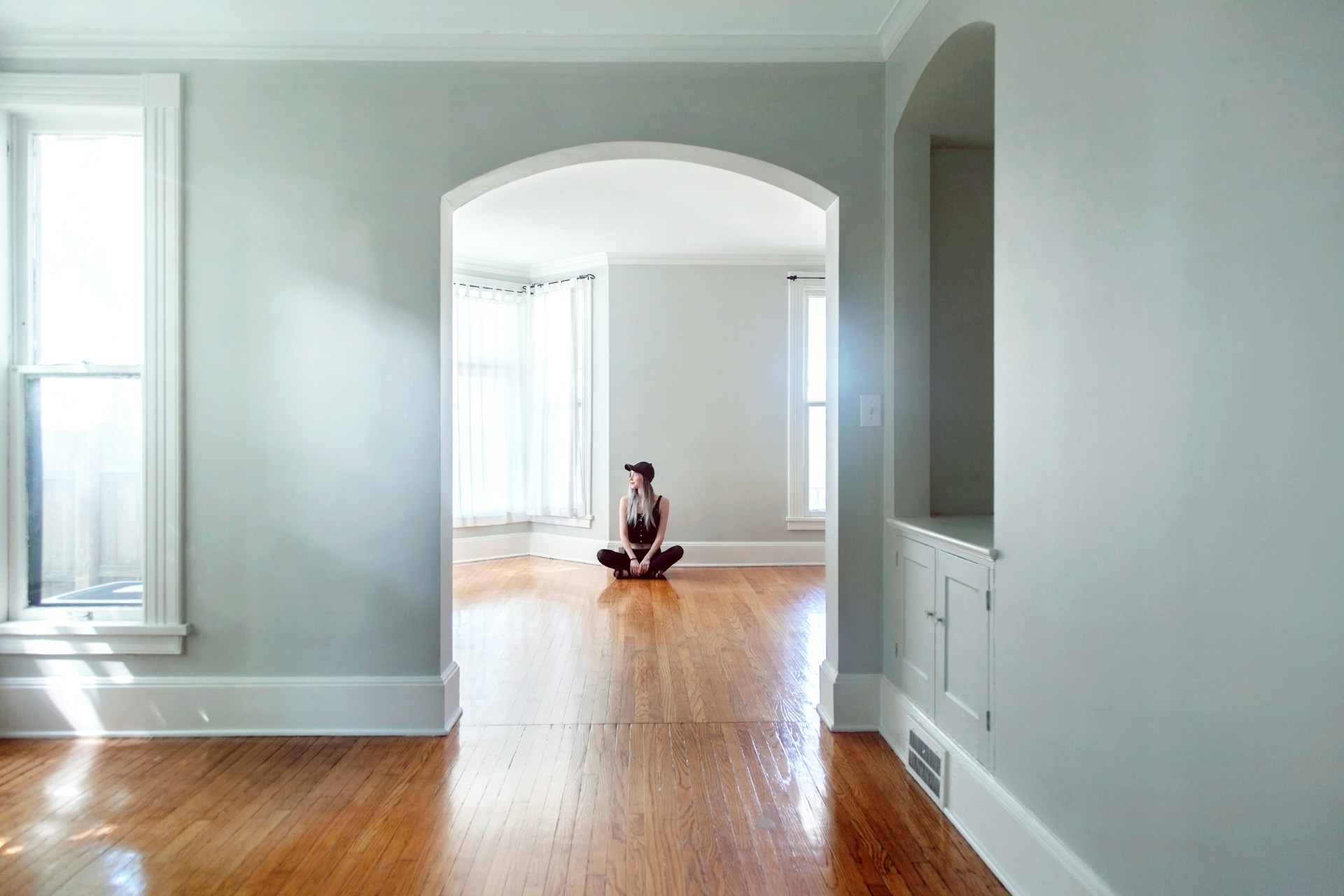 woman sitting on the floor in empty house woman sitting on the floor in empty house