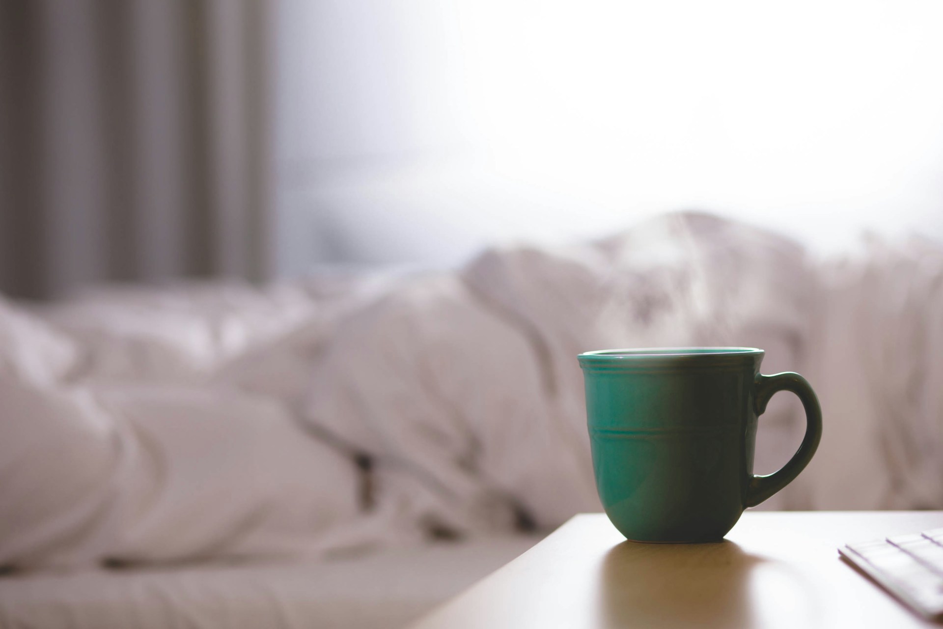 steaming green mug next to bed steaming green mug next to bed