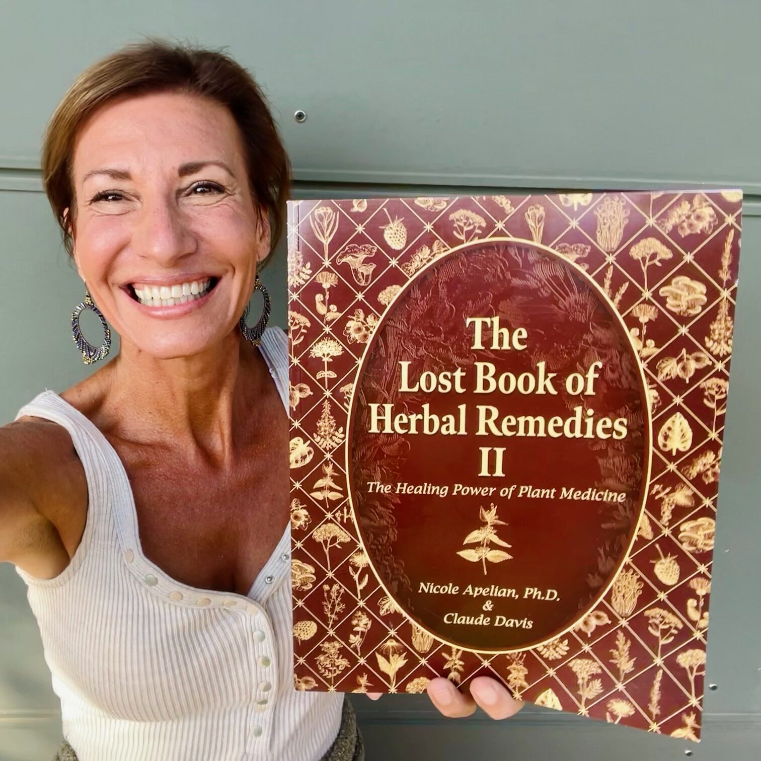 Nicole Apelian holding The Lost Book of Herbal Remedies Volume II