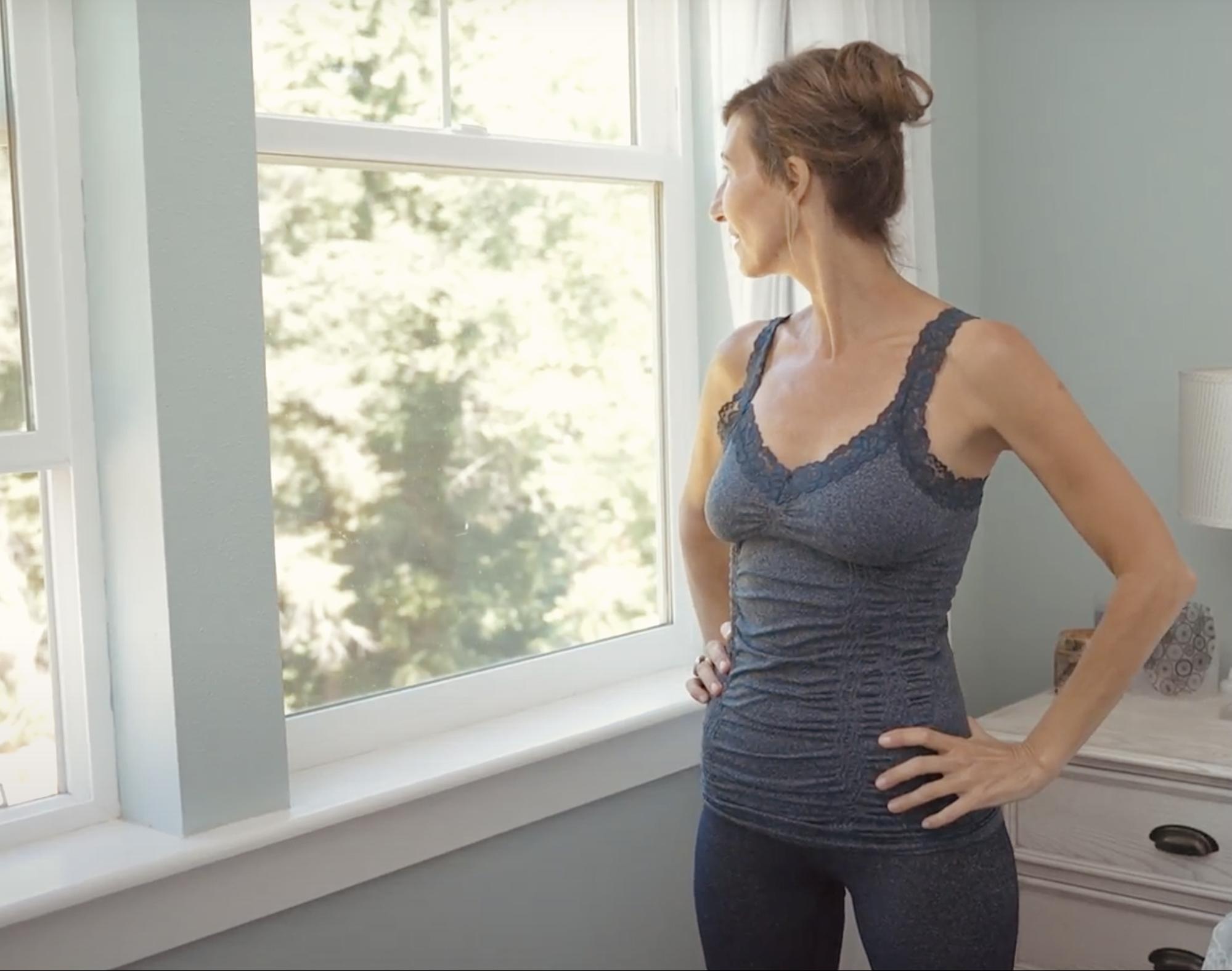 Nicole Apelian looking out bedroom window Is Sleeping on Your Back Harming Your Brain?