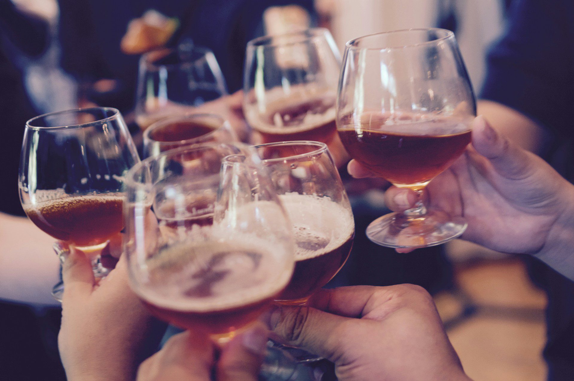 many hands toasting with glasses