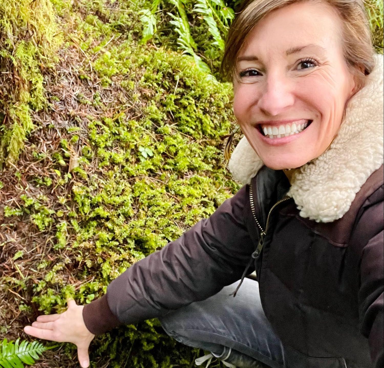 Nicole Apelian touching forest floor Rooted in Nature: Why Gardens, Parks, & Forests Are Essential For Well-Being