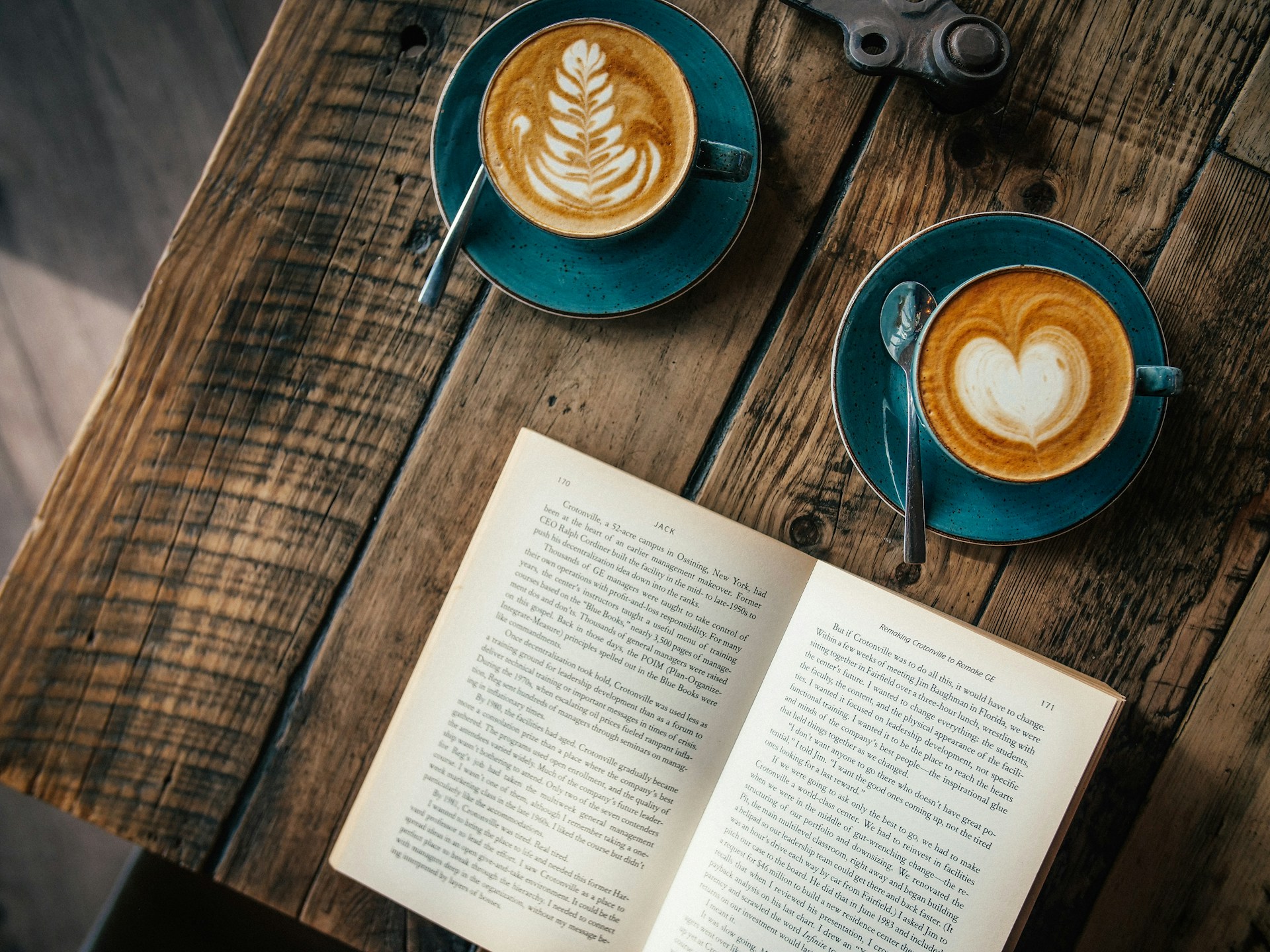open book and lattes on table open book and lattes on table