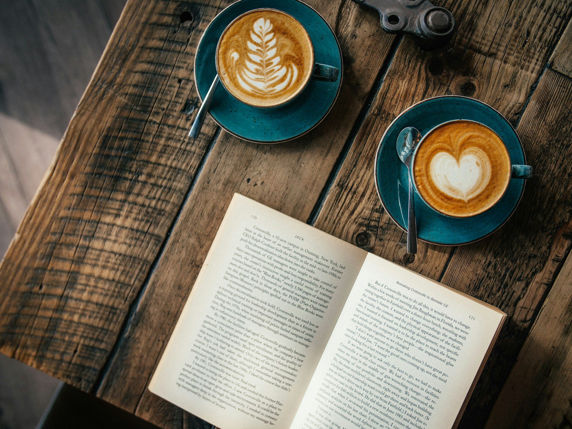 open book and lattes on table
