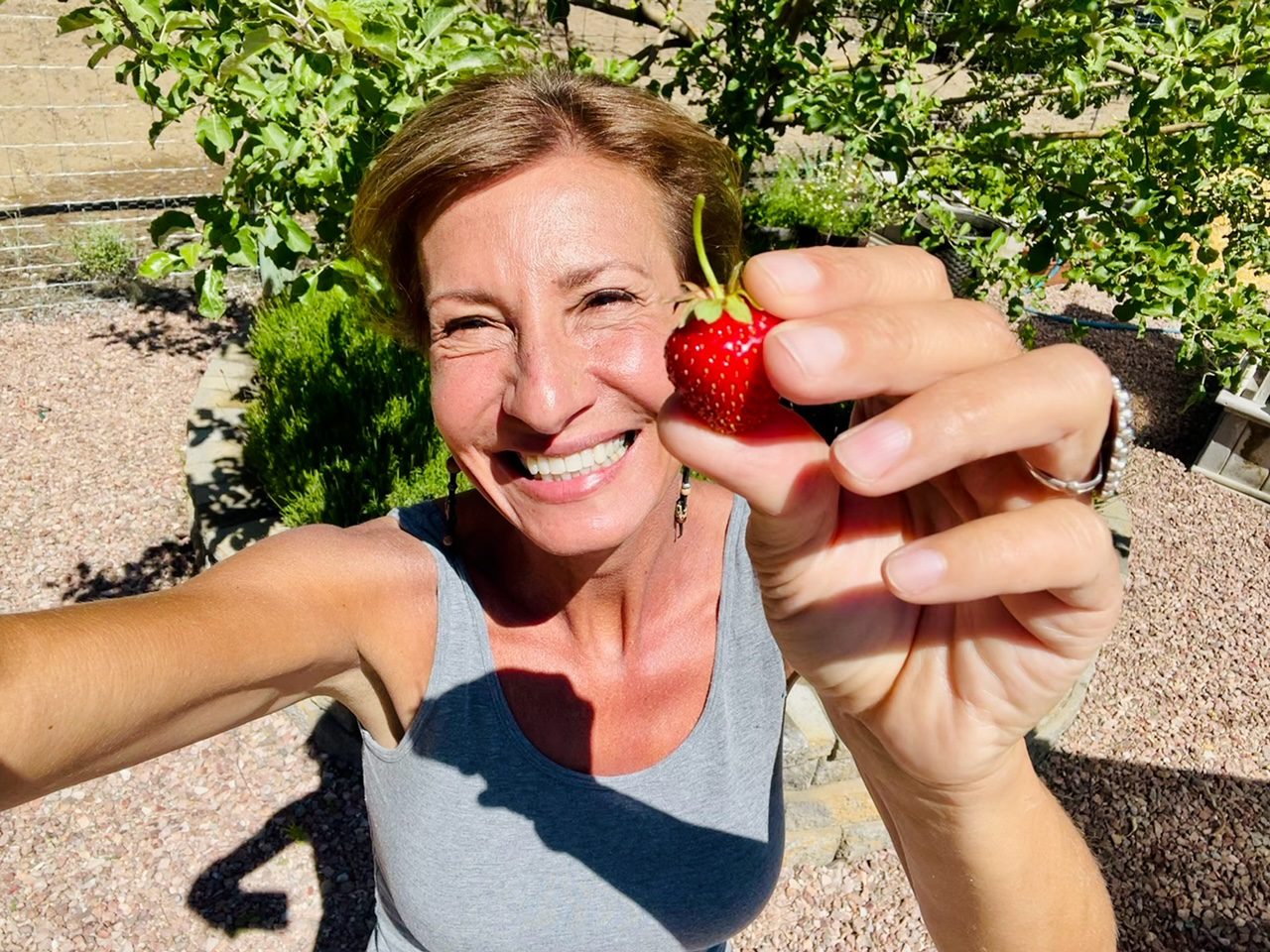 Nicole Apelian holding fresh strawberry Can Eating More Carbs Help Your Thyroid? Here’s What Science Says