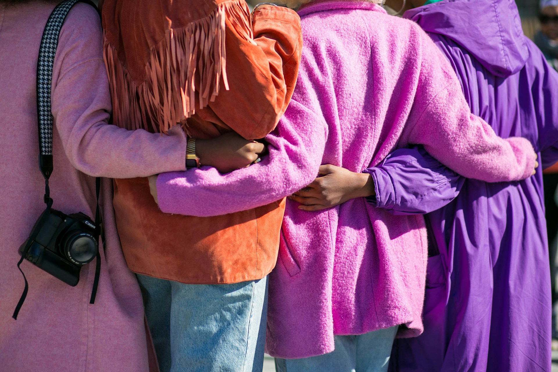 women hugging in bright coats women hugging in bright coats