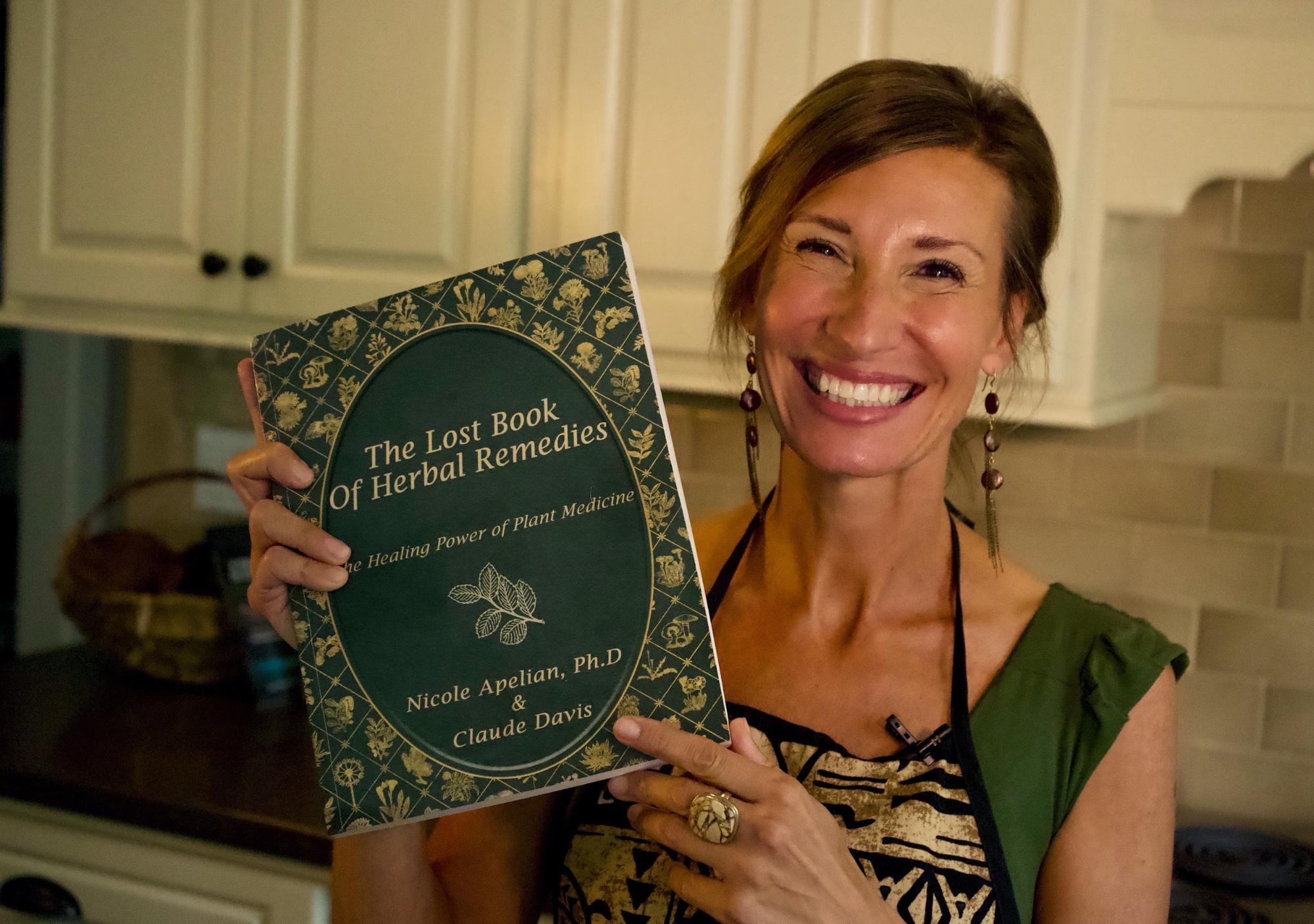 Nicole Apelian holding The Lost Book of Herbal Remedies