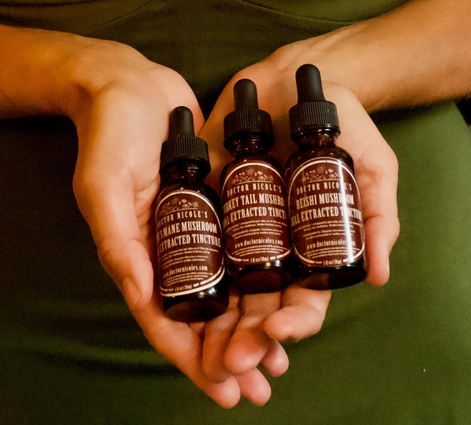 Nicole Apelian holding her Mushroom Trio of tinctures