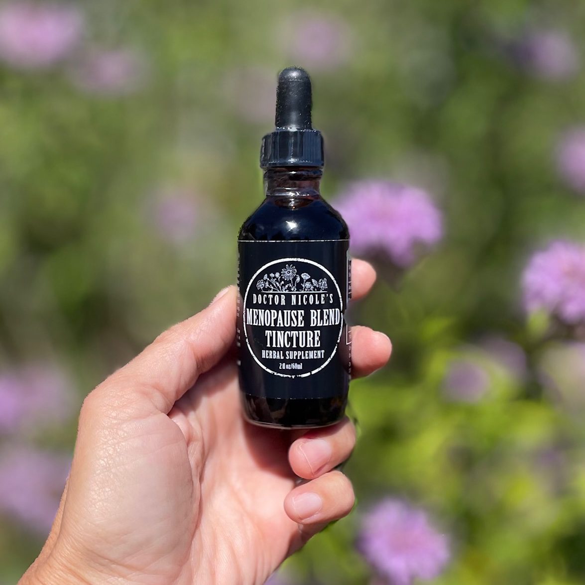 hand holding Nicole's Apothecary Menopause Blend Tincture Nicole Apelian holding Menopause Blend Tincture