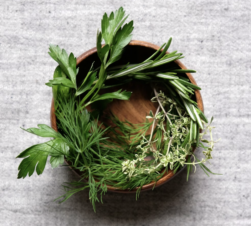 fresh herbs in a small wooden bowl