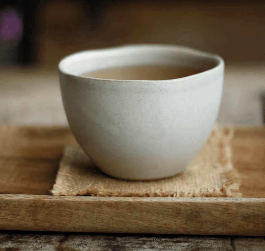 white ceramic cup of tea on wooden tray